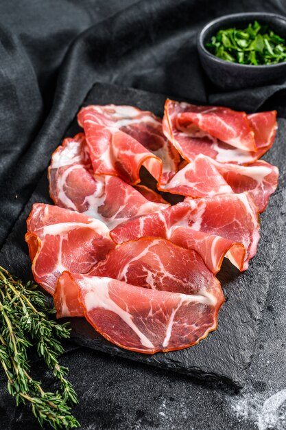 Coppa, Capocollo, Capicollo carne popolare antipasto italiano. Sfondo nero.