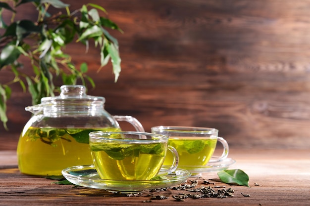 Coppe di tè verde sul tavolo su uno sfondo di legno