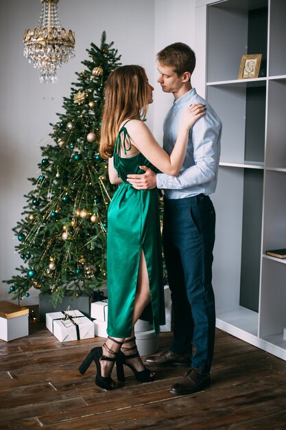 Coppia a casa vicino a un albero di Natale. Vigilia di Natale.