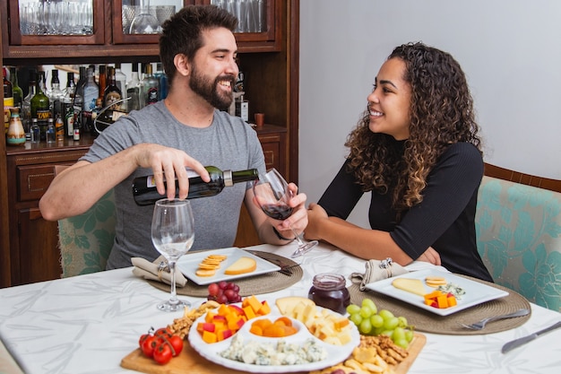 Coppia a cena romantica degustazione di vino e formaggio. Coppia con spuntini vino e formaggio in inverno