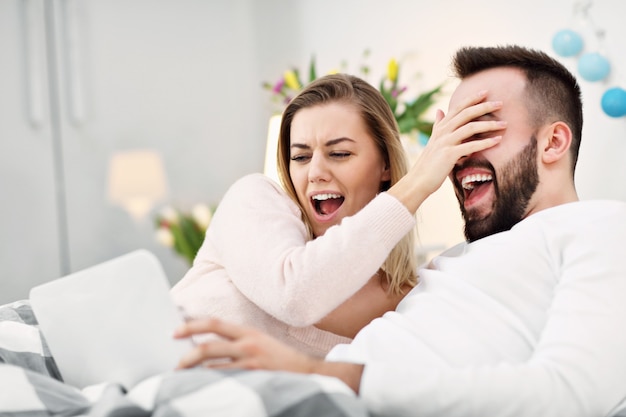 coppia a letto che guarda la TV