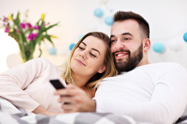 coppia a letto che guarda la TV