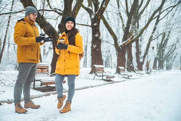 Coppia a piedi dal parco cittadino innevato parlando di socializzare. appuntamento romantico in inverno. Natale sta arrivando