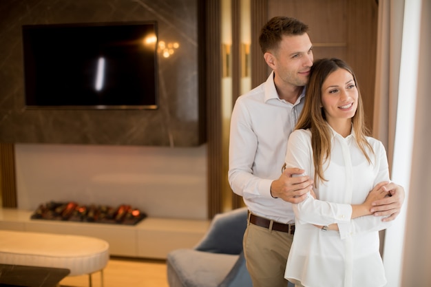 Coppia abbracciando in piedi nel soggiorno di un appartamento contemporaneo