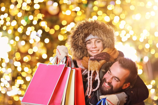 coppia adulta che fa shopping in città durante il periodo natalizio