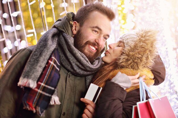 coppia adulta che fa shopping in città durante il periodo natalizio