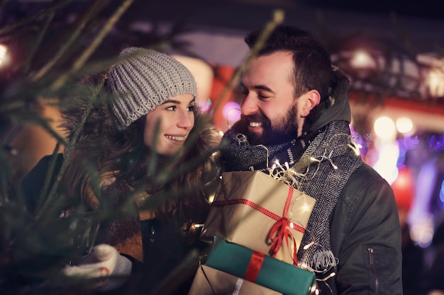 coppia adulta che sceglie l'albero di Natale in città durante il periodo natalizio