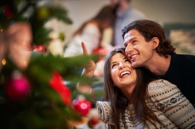 coppia adulta che si diverte sull'albero di Natale