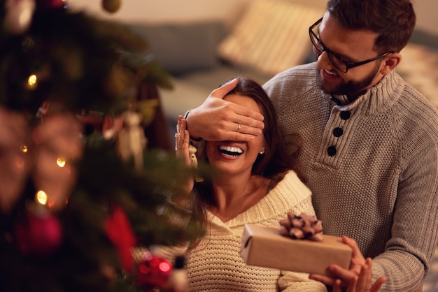 coppia adulta con regalo sopra l'albero di Natale