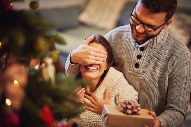 coppia adulta con regalo sopra l'albero di Natale