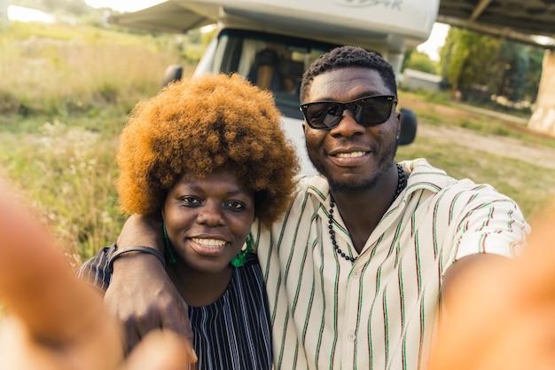 Coppia africana che si fa un selfie davanti a un veicolo ricreativo