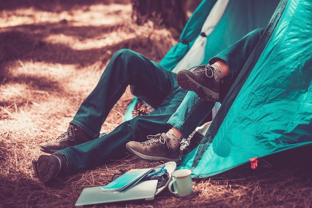 Coppia all'interno di una tenda in campeggio libero natura boschi e stile di vita di viaggio Persone che si godono attività ricreative all'aperto Viaggiatore all'interno della tenda blu Libertà persone e stile di vita naturale Vacanza alternativa