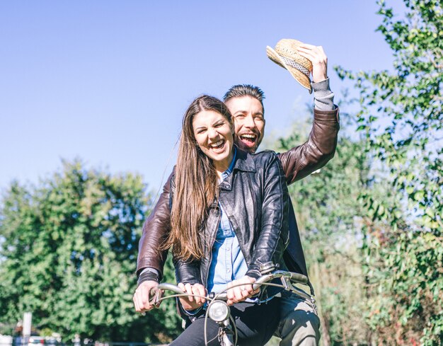 Coppia andare in bicicletta e ridere