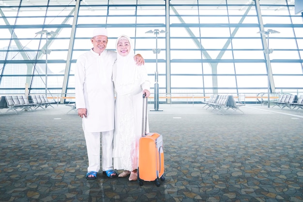Coppia anziana musulmana che tiene un bagaglio in aeroporto