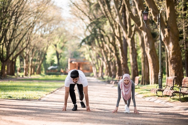 Coppia araba in abbigliamento sportivo si prepara per la corsa al parco