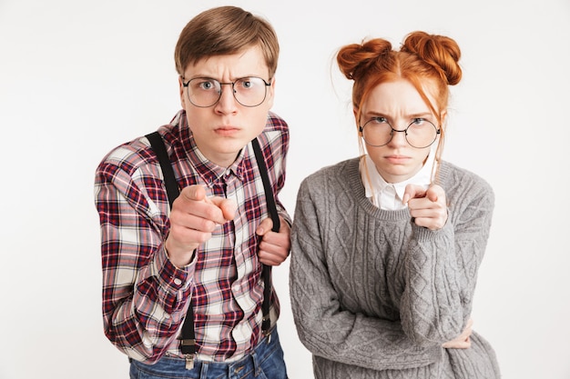 Coppia arrabbiata di nerd della scuola che punta il dito