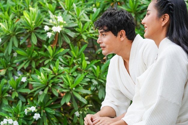 Coppia asiatica che indossa accappatoio parlando al balcone nella camera d'albergo