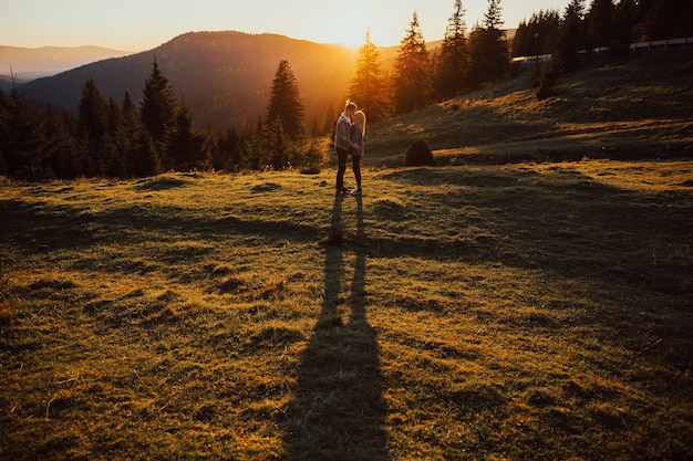 Coppia baciarsi e abbracciarsi sulla montagna con un paesaggio incredibile.