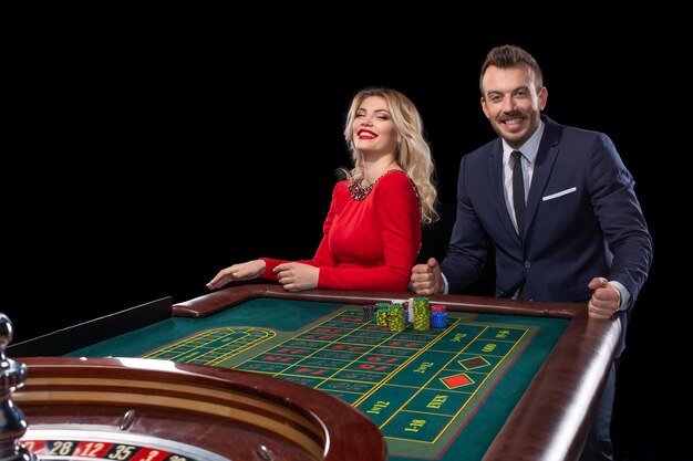 Coppia bella e ben vestita che gioca alla roulette al casinò