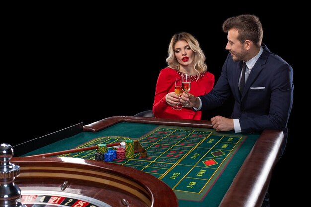 Coppia bella e ben vestita che gioca alla roulette al casinò