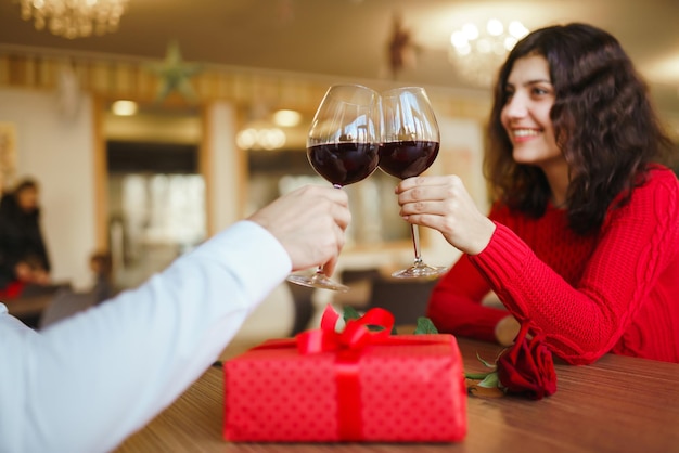 Coppia bicchieri tintinnanti con vino rosso Gli amanti si scambiano regali Bella cena romantica