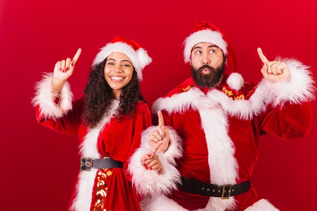 Coppia brasiliana vestita per natale babbo natale mummia claus che balla donna nera e uomo caucasico