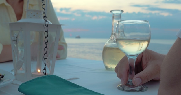 Coppia brindando con vino nel ristorante sulla spiaggia