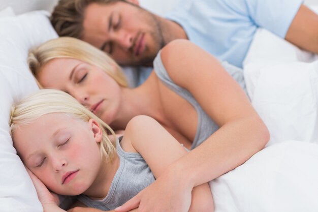 Coppia carina che dorme con la figlia