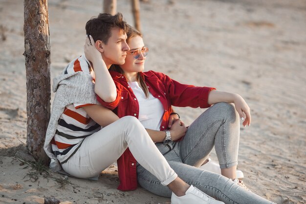 Coppia carina divertirsi in riva al mare. Concetto di amore e relazione. Giovane donna e uomo che camminano insieme lungo la linea di costa.