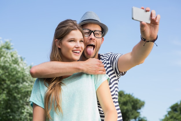 Coppia carina nel parco prendendo selfie