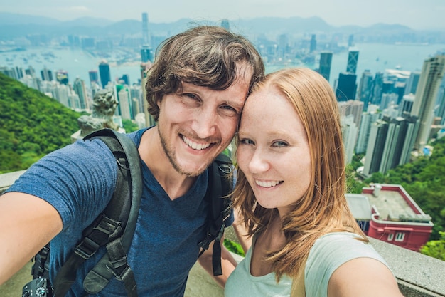 Coppia caucasica a Hong Kong. Giovani che scattano foto selfie al punto di vista della famosa attrazione Victoria Peak, HK, Cina.