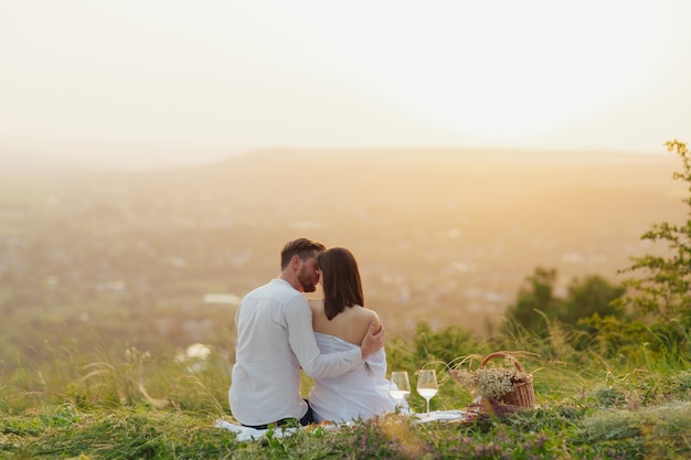 Coppia che beve vino a un picnic in un campo