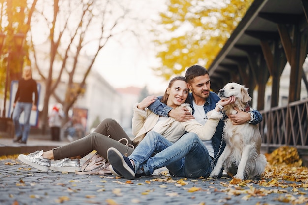 coppia che cammina con il loro cane in una giornata di sole autunnale