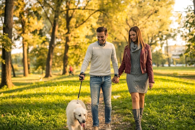 Coppia che cammina con il loro cane nel parco