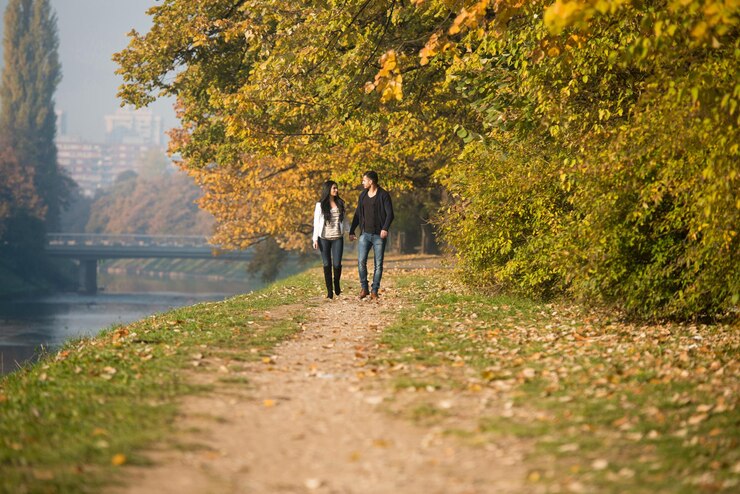 Foto coppia che cammina nella foresta attraverso i boschi fuori durante l'autunno