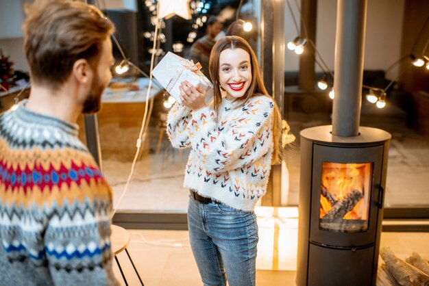 Coppia che celebra le vacanze invernali con regali a casa