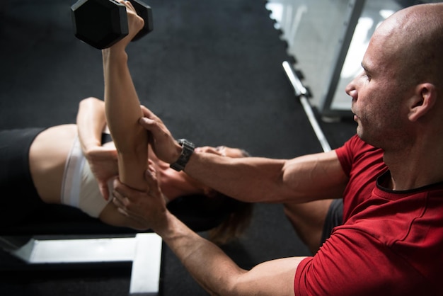 Coppia che esercitano i tricipiti con i manubri in palestra