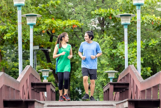 Coppia che fa jogging e corre in un ambiente naturale la mattina d'estate