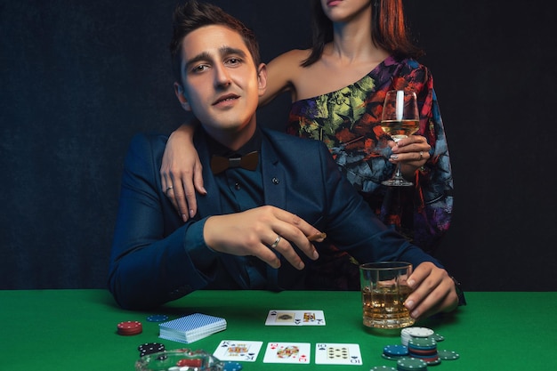 Coppia che gioca a poker al tavolo verde del casinò.