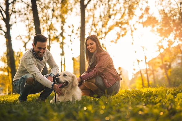 Coppia che gioca con il loro cane nel parco