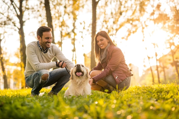 Coppia che gioca con un cane nel parco