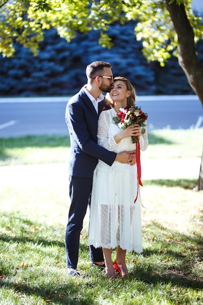 Coppia che gode di momenti romantici nel parco Sposa elegante in un bellissimo abito bianco sposo in abito