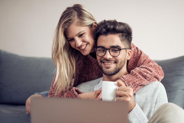 Coppia che guarda un film sul laptop nel loro soggiorno