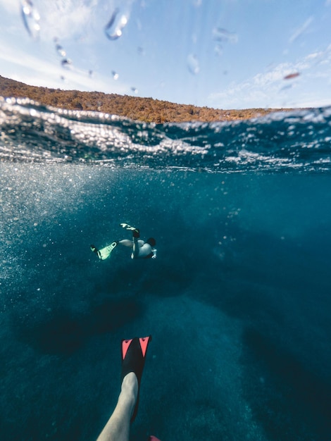 Coppia che nuota sott'acqua con maschera e pinne da immersione vacanze estive al mare