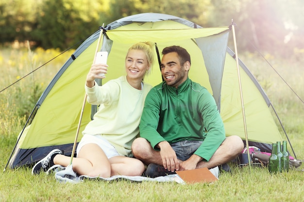 coppia che si accampa nella foresta e si fa un selfie