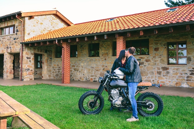 Coppia che si bacia con una moto personalizzata