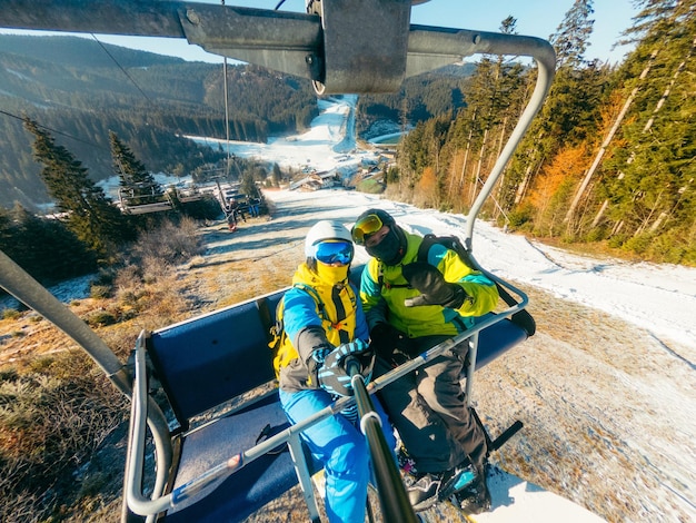 Coppia che si fa un selfie mentre sale sulla stazione sciistica della seggiovia