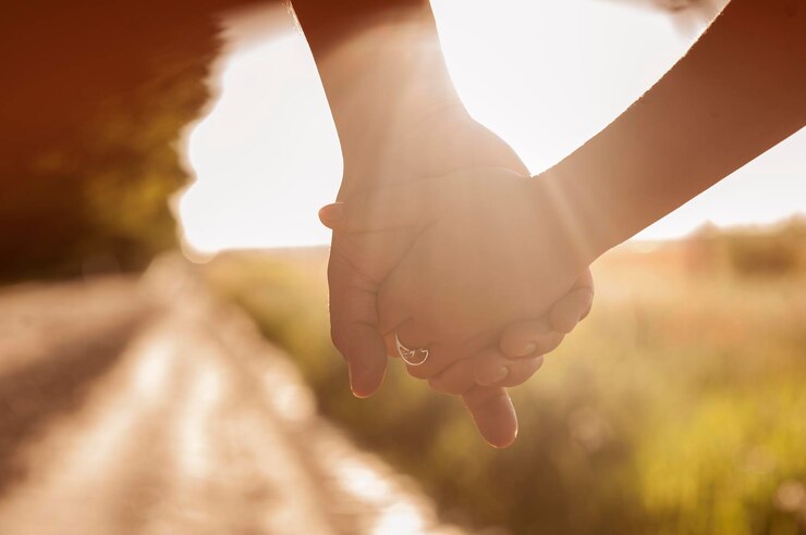 Coppia che si tiene per mano al tramonto Le persone che tengono la mano insieme il concetto di amore