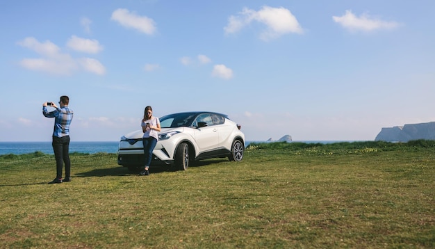 Coppia che viaggia in auto fotografando il paesaggio