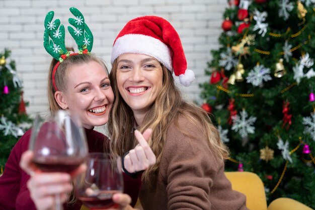 Coppia con bicchieri di vino rosso vicino al camino bella giovane donna caucasica in maglione